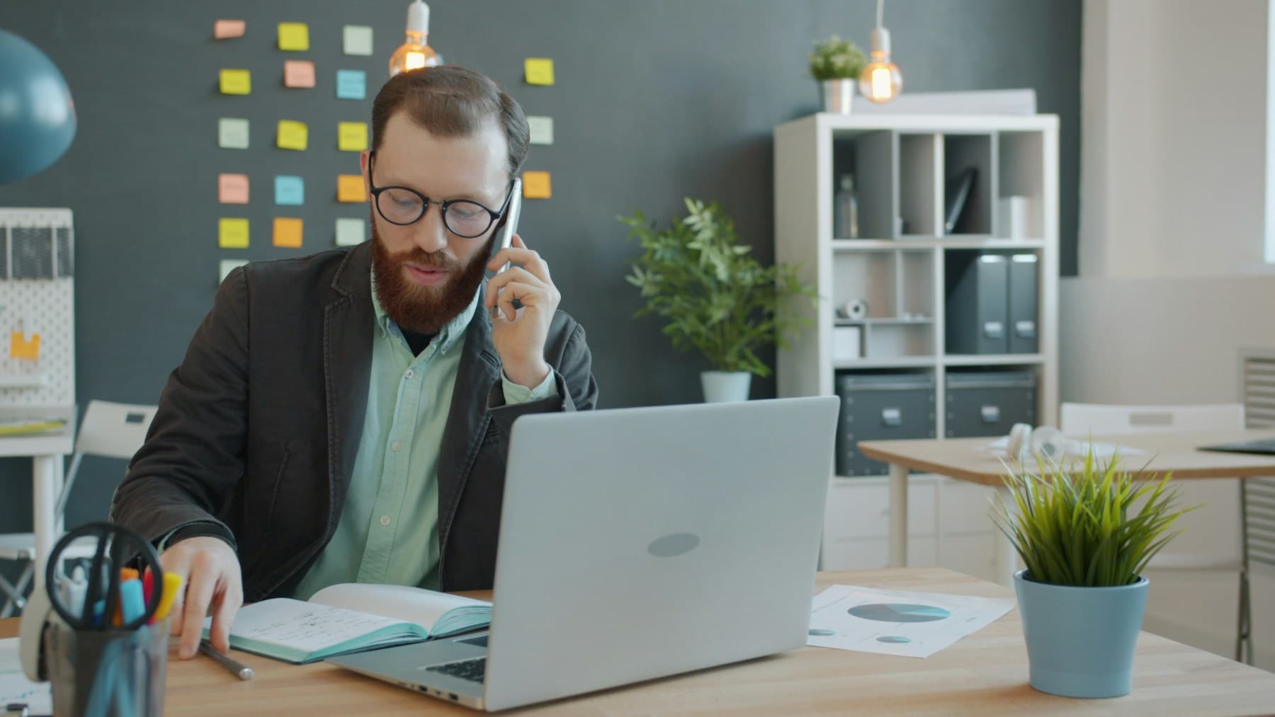 An advisor on a phone call at his laptop